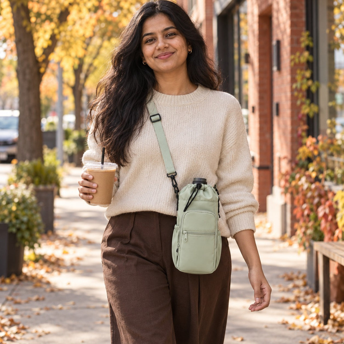Sage tumbler sling worn crossbody on a fall coffee walk