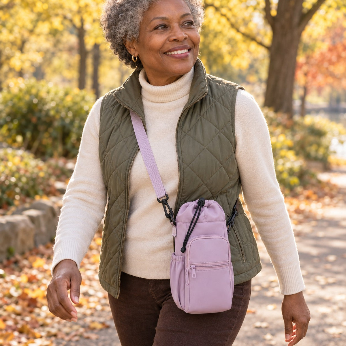 Lavender tumbler sling worn crossbody on a park walk